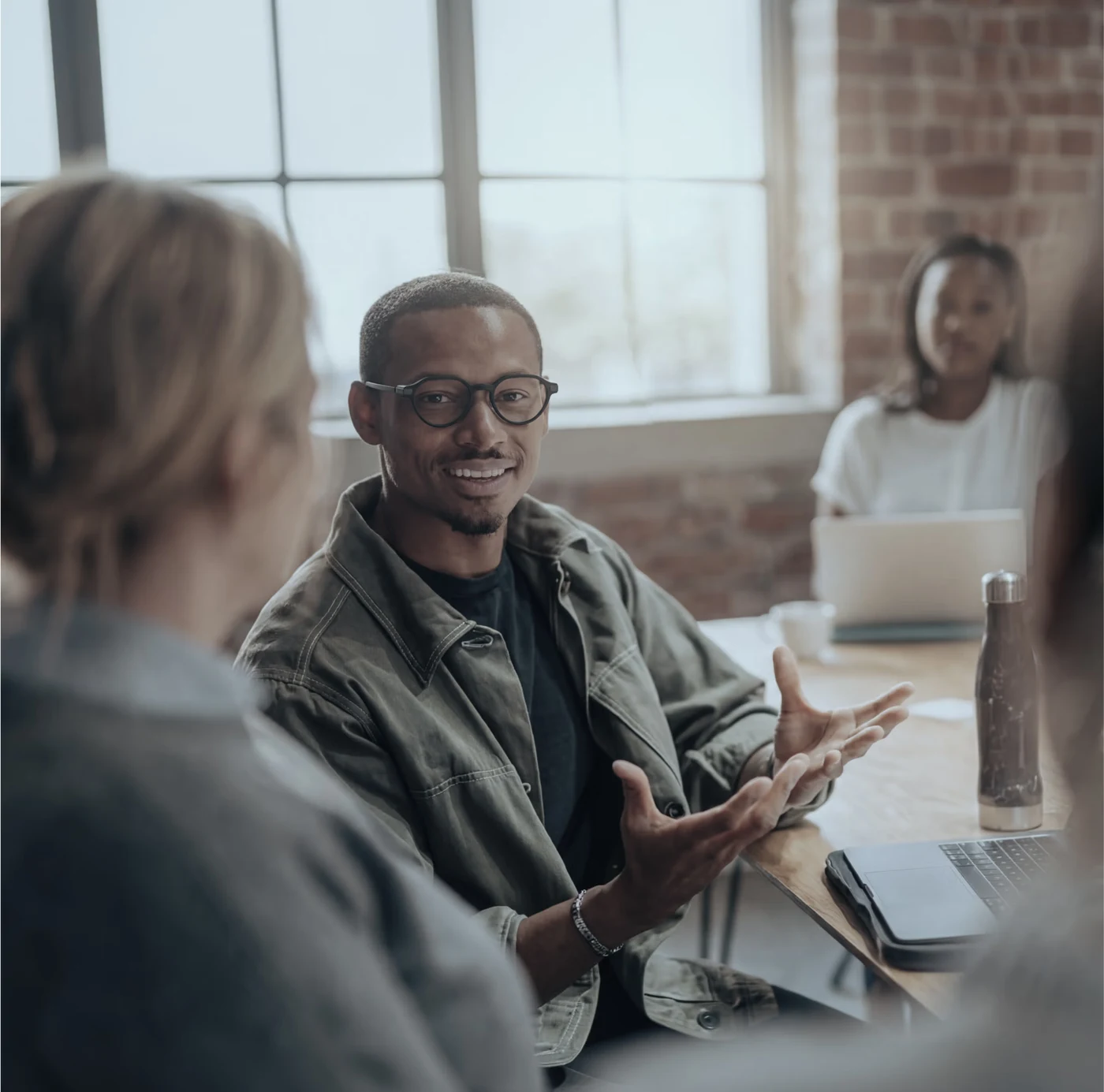 Person wearing Even Realities G2 smart glasses during an office discussion