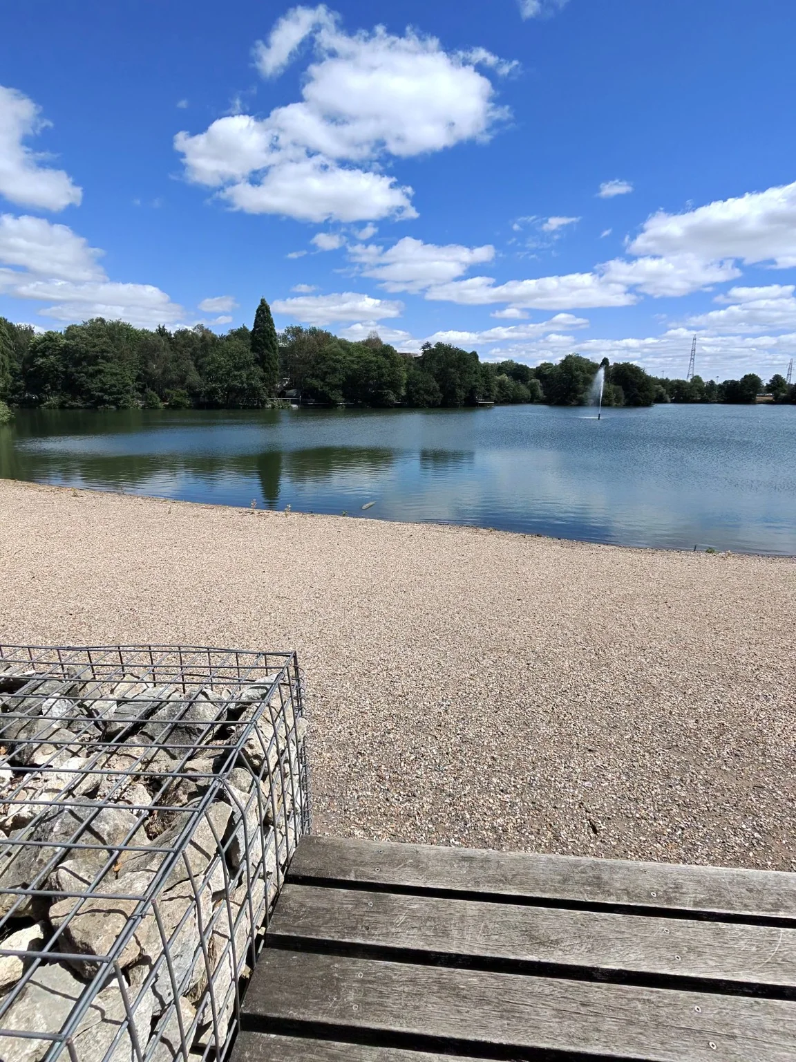First Ray-Ban Meta photo attempt of a lake, with a bench and stone cage taking up much of the foreground
