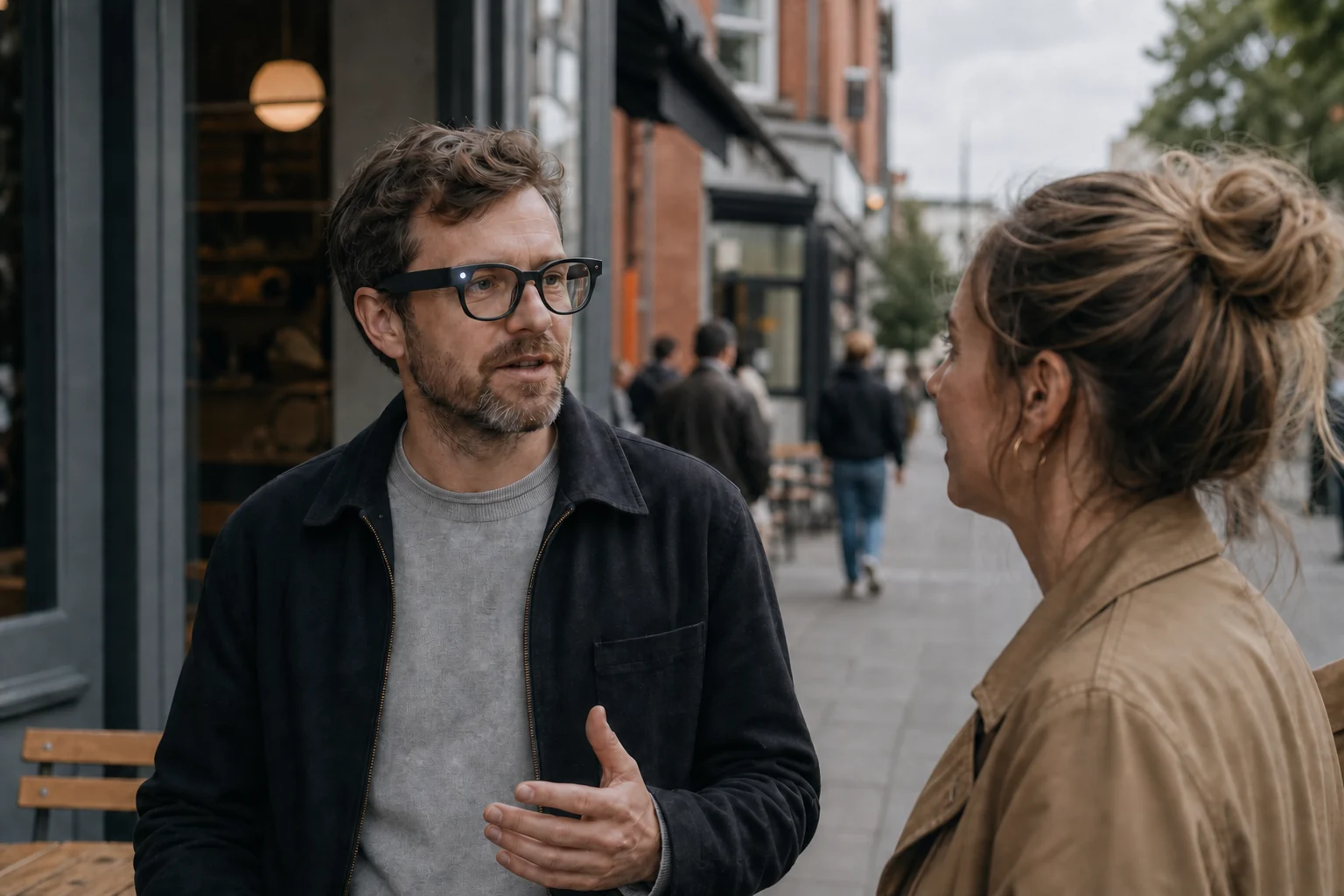 Two people talking on a city street while the recording light on camera glasses is visible